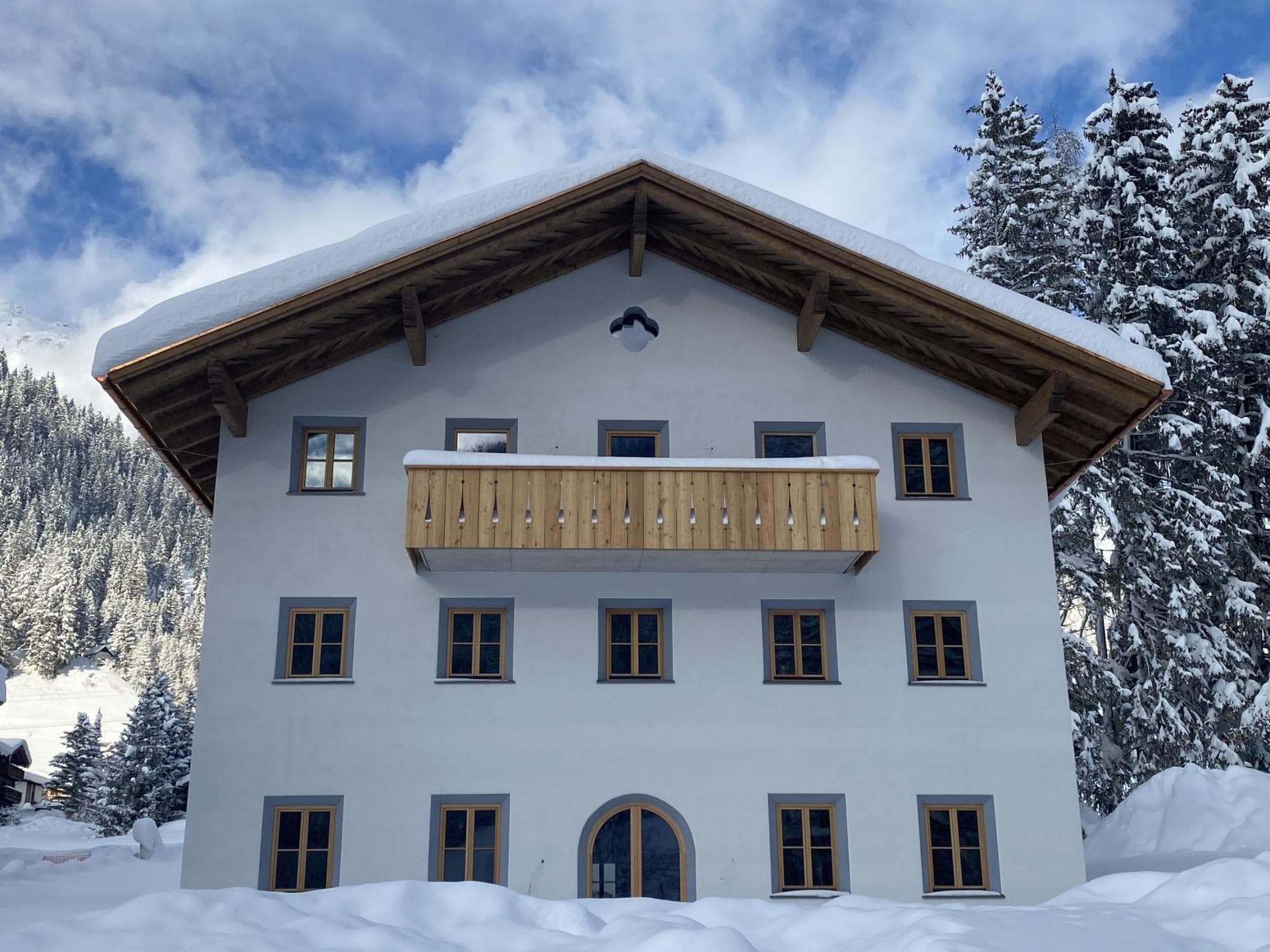 Chalet exterior with timber balcony and snow-covered eaves