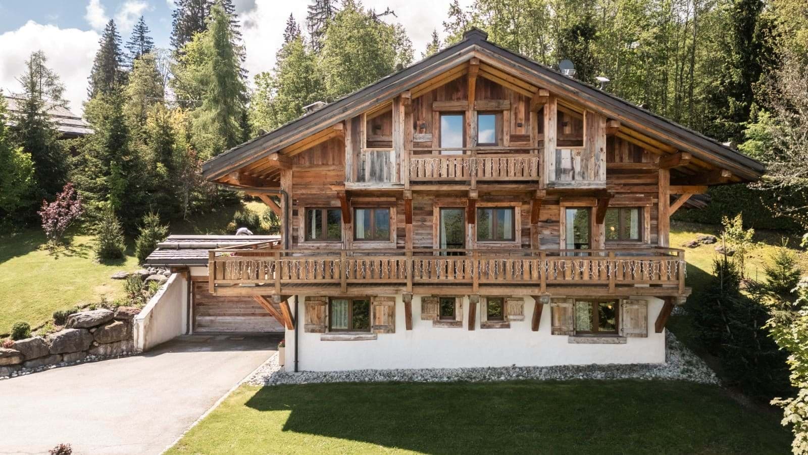Three-story timber chalet with wrap-around balconies and heated driveway garage
