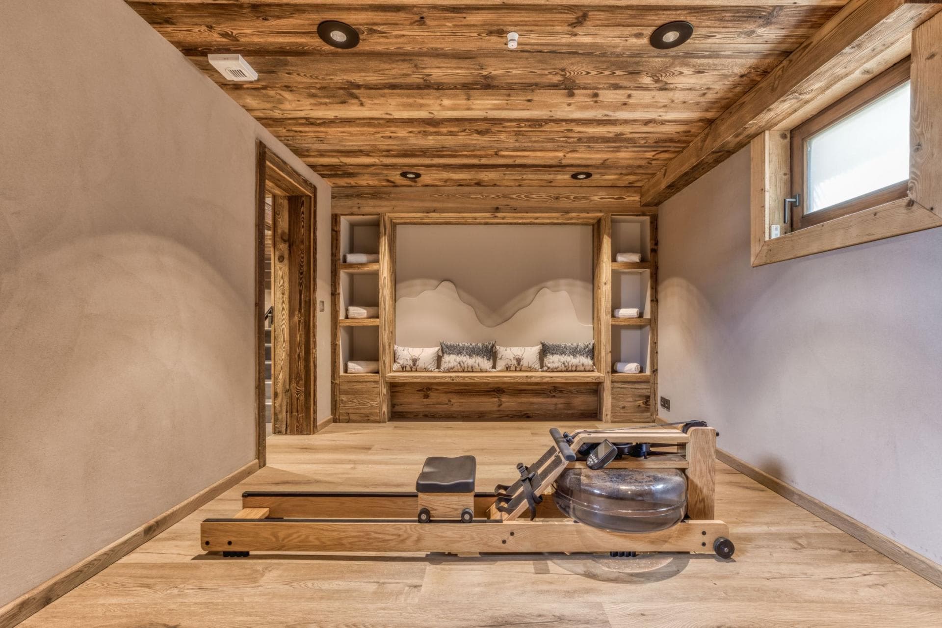 Fitness room with WaterRower rowing machine and towel storage