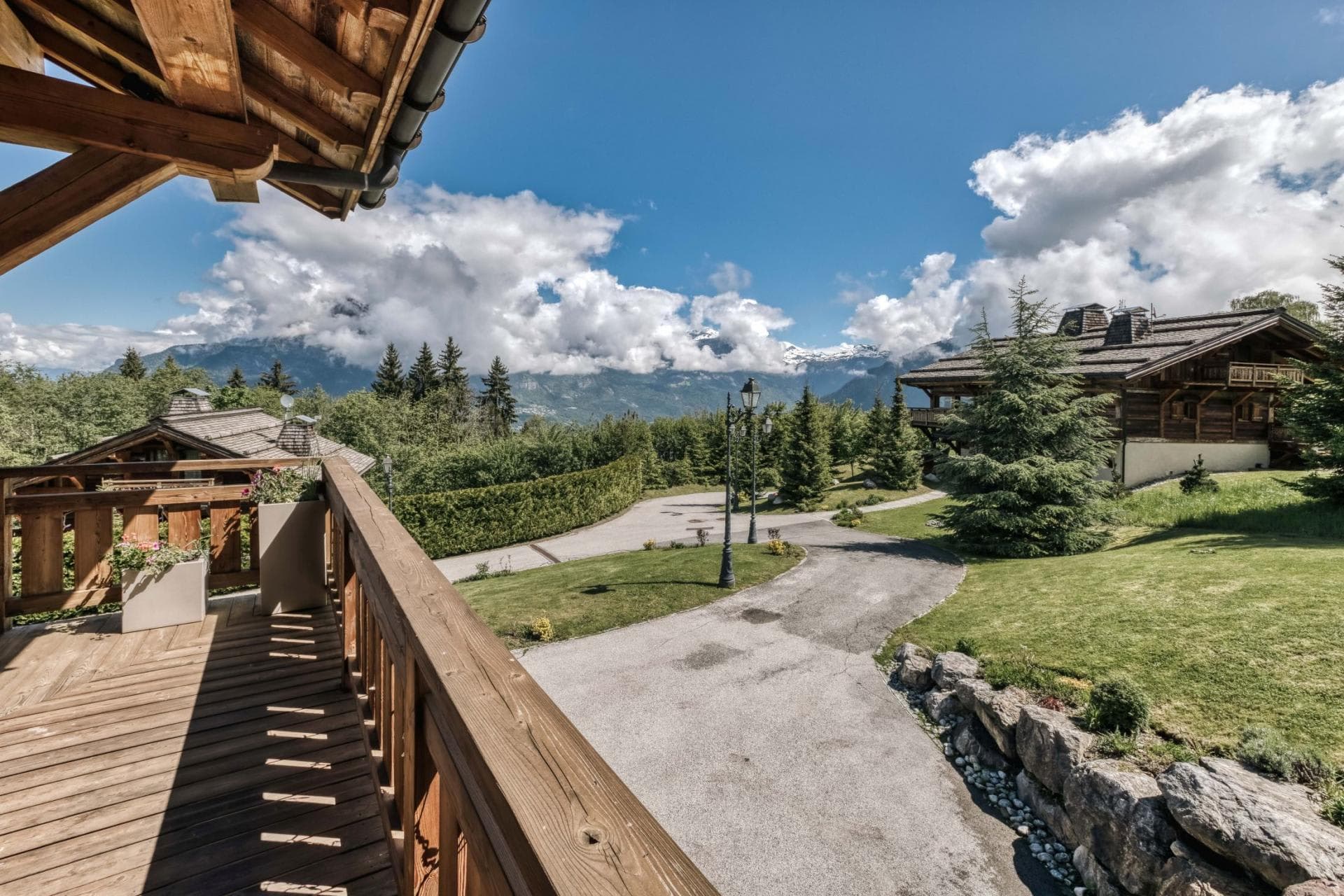 Covered balcony with views of landscaped grounds and mountain peaks