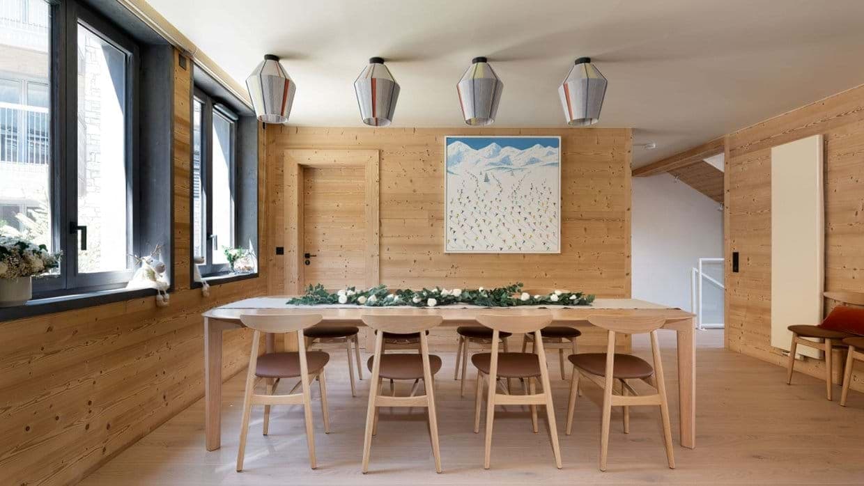 Dining area with seating for 8 and light wood-paneled walls
