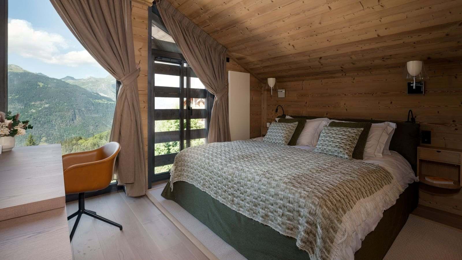 Bedroom with king bed and mountain views; vaulted wood ceiling