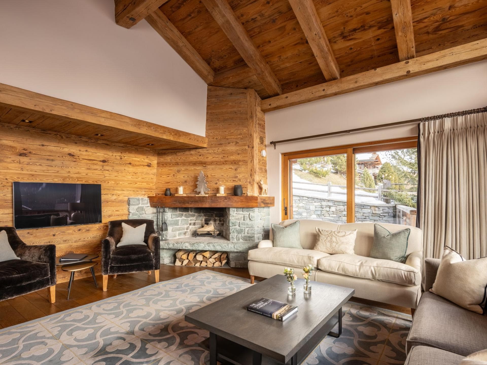 Living area with wood-burning fireplace and vaulted timber ceilings