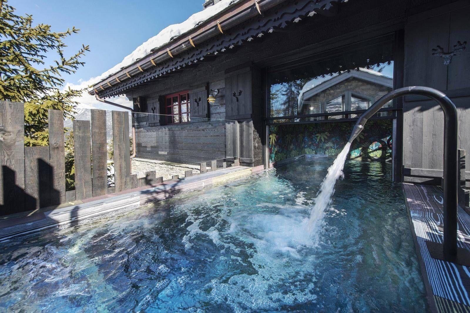 Outdoor pool with waterfall feature and swim-through access to indoors