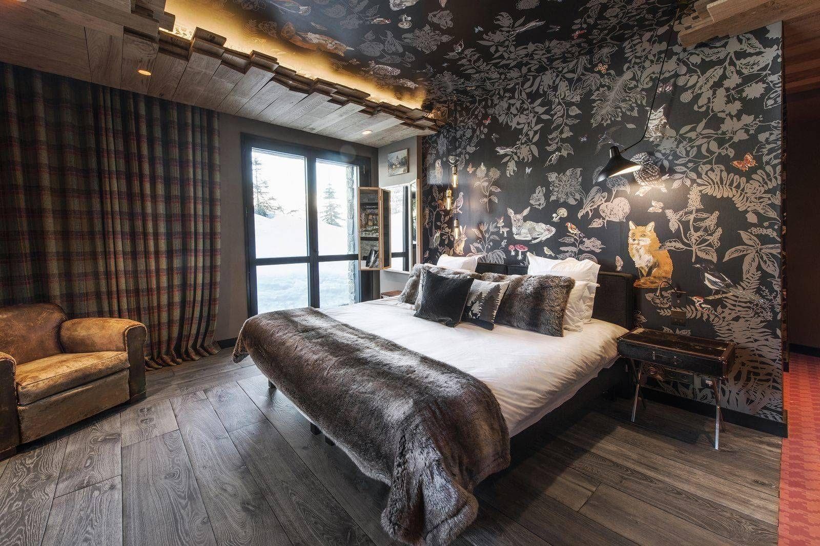 Bedroom with king bed, forest-themed wallpaper, and ski slope views