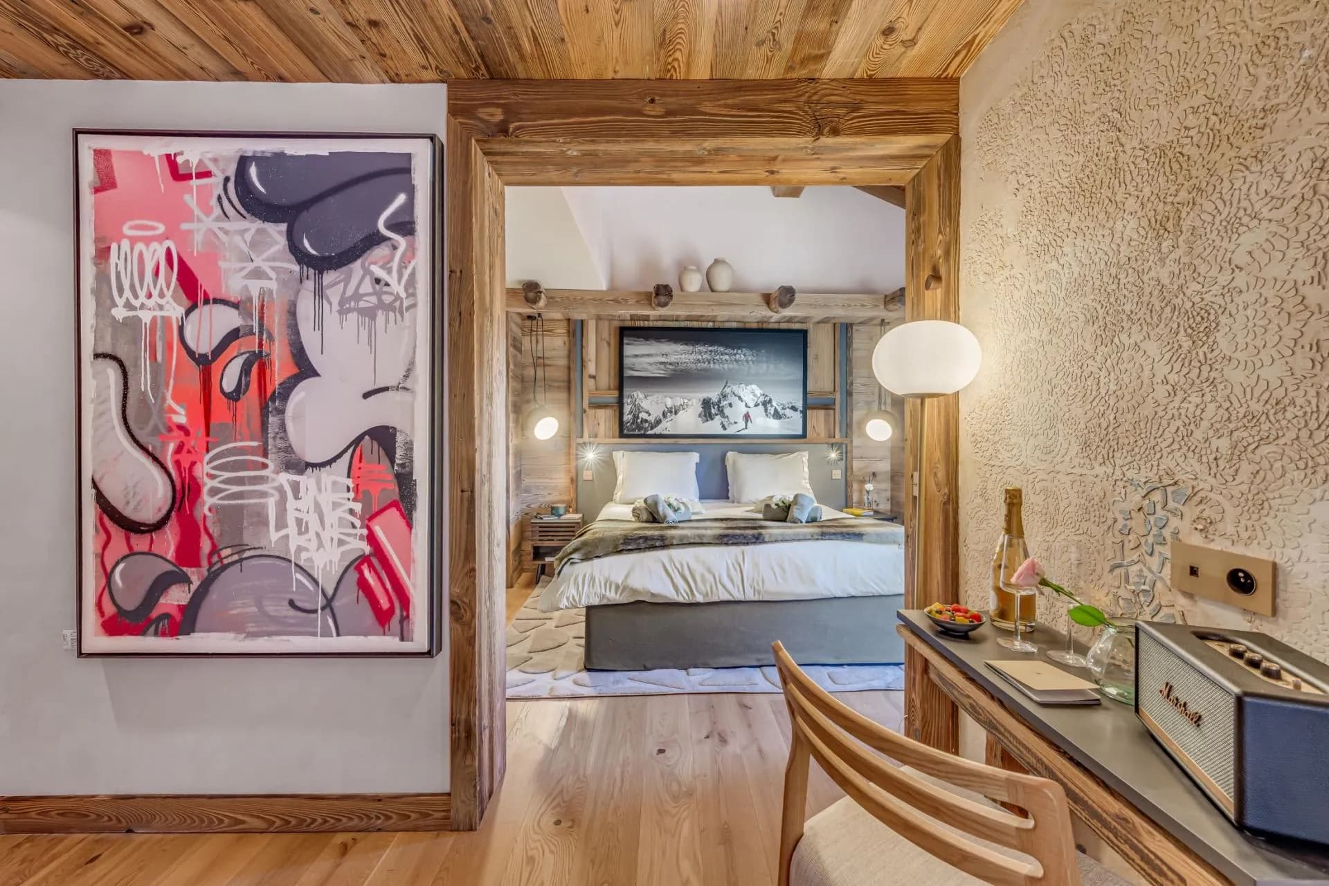 Primary bedroom with king bed and desk featuring Marshall speaker