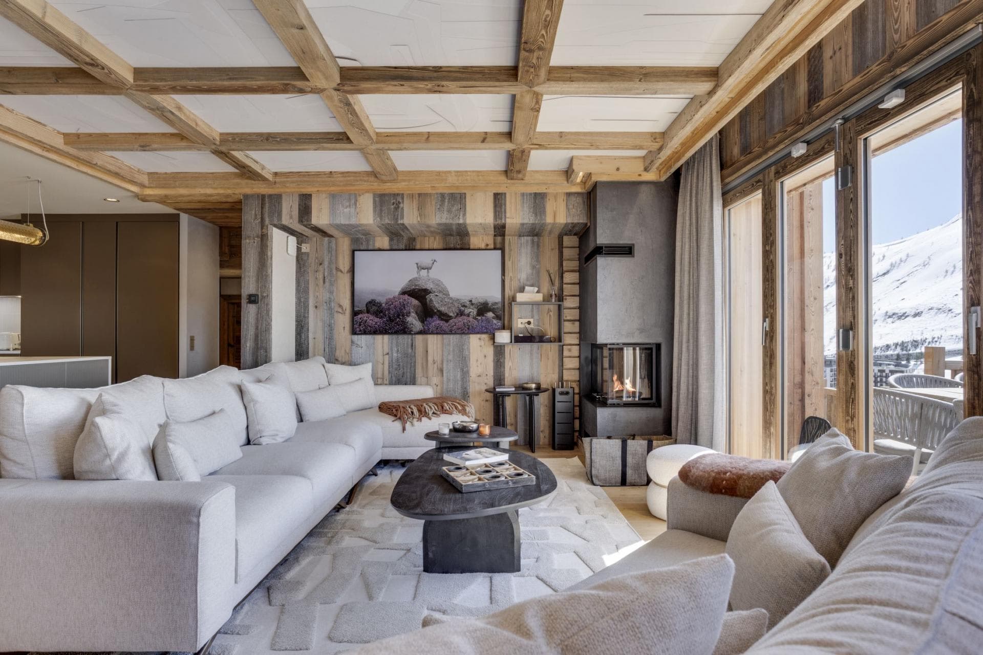 Living room with sectional seating and corner fireplace; snowy mountain views