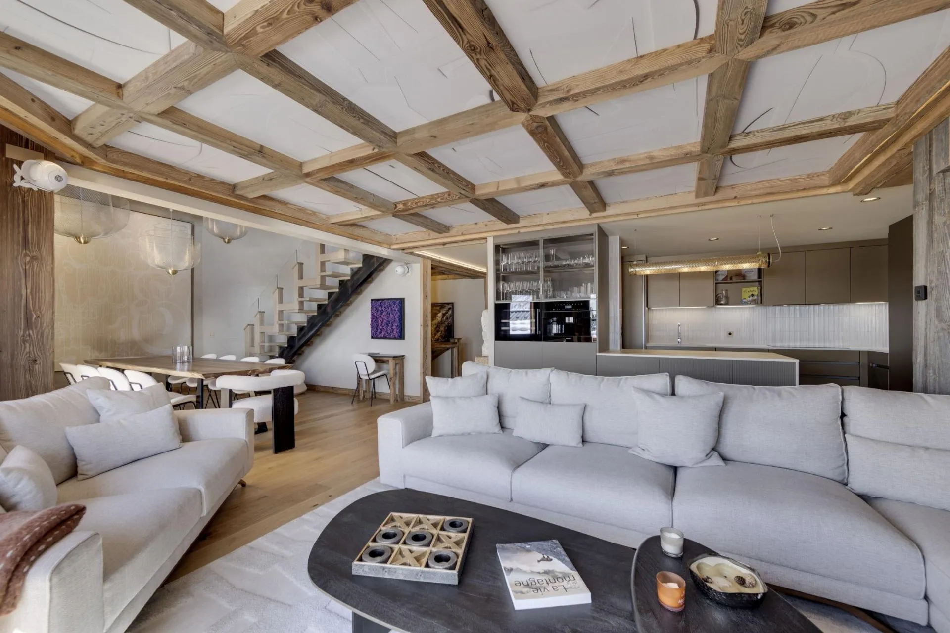 Open-plan living space with coffered wood ceiling and dining seating for 8