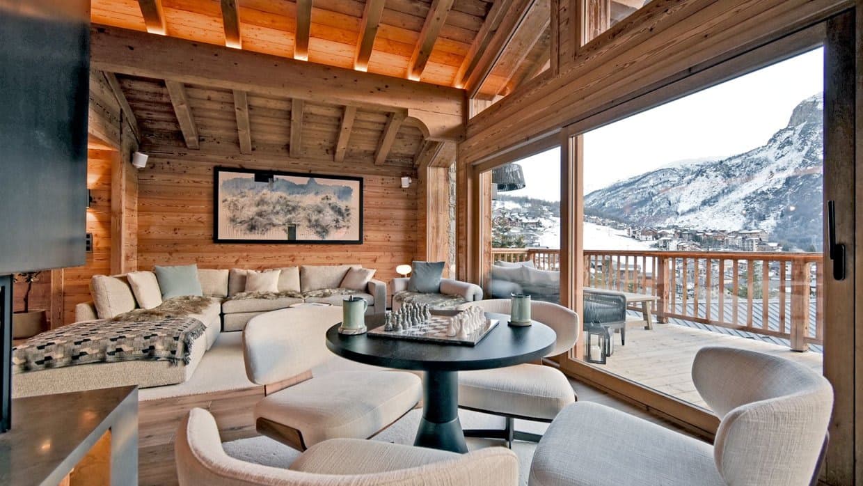 Living area with chess table and floor-to-ceiling mountain views
