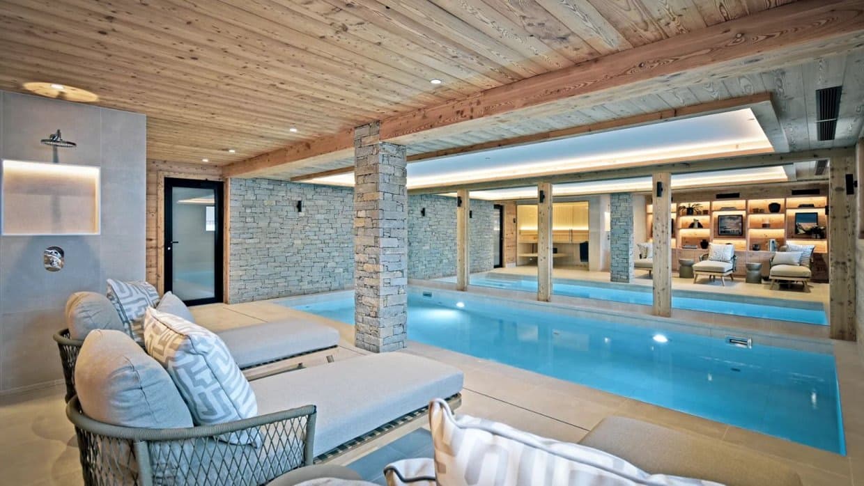 Indoor lap pool with stone pillars and integrated open shower