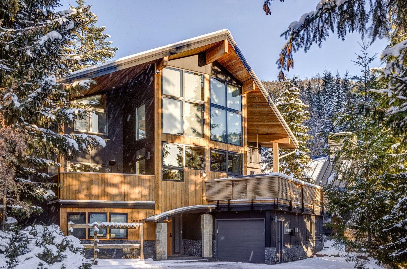 Chalet exterior with two-car garage and elevated wrap-around sun deck