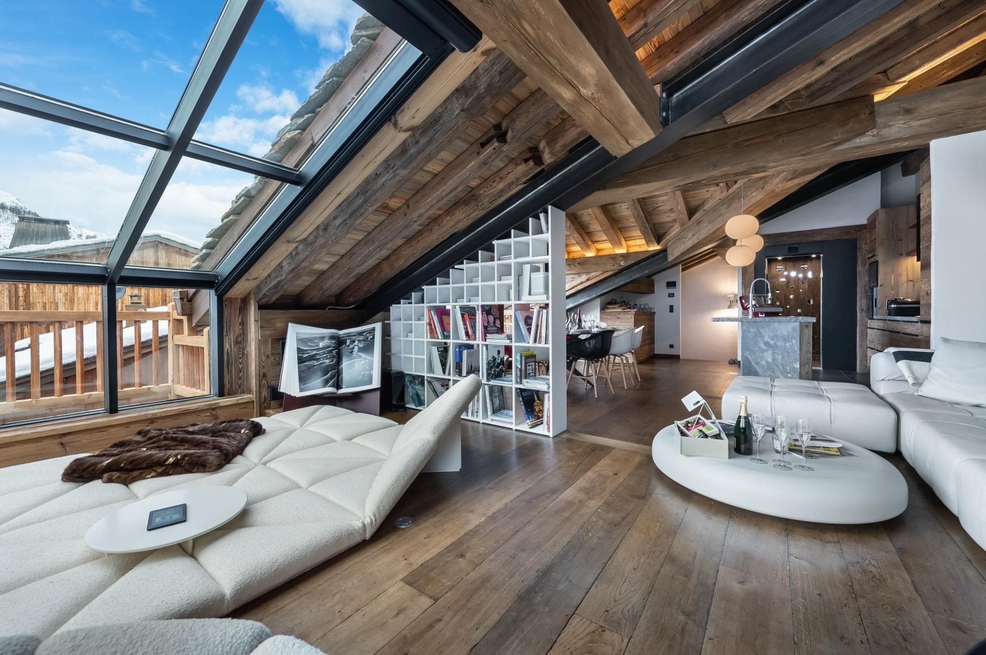 Loft living area with glass roof and views of snowy peaks