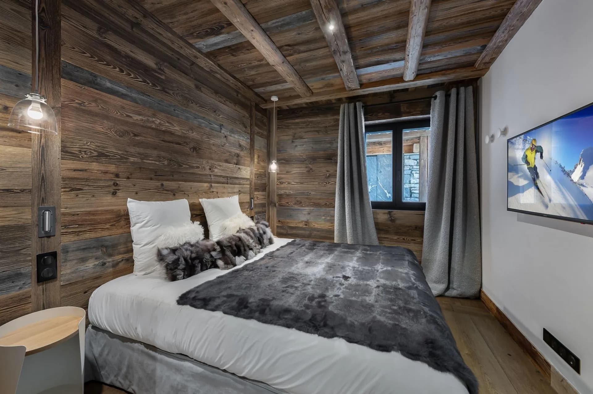 Double bedroom beneath timber beams with curtains