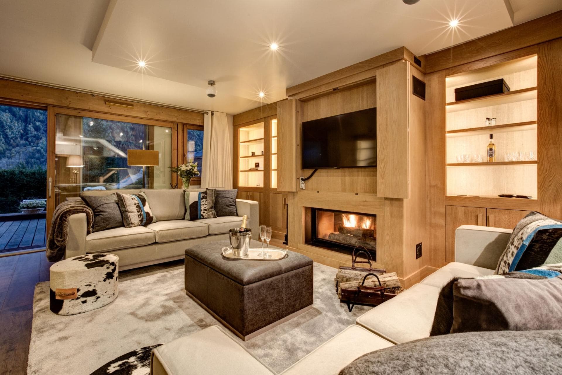 Living room with wood-burning fireplace and sliding door to private deck