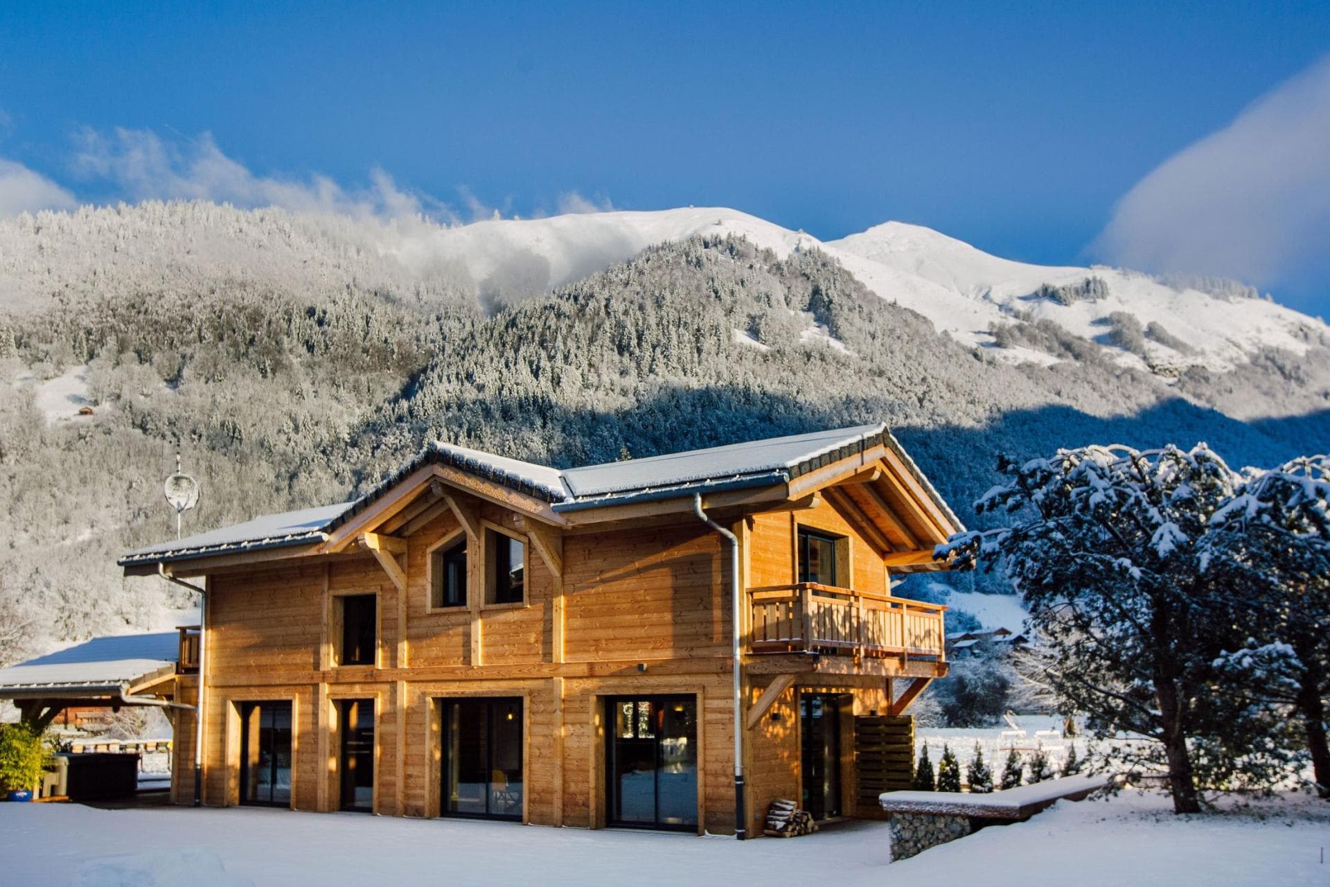 Timber chalet with private balcony and snowy mountain backdrop