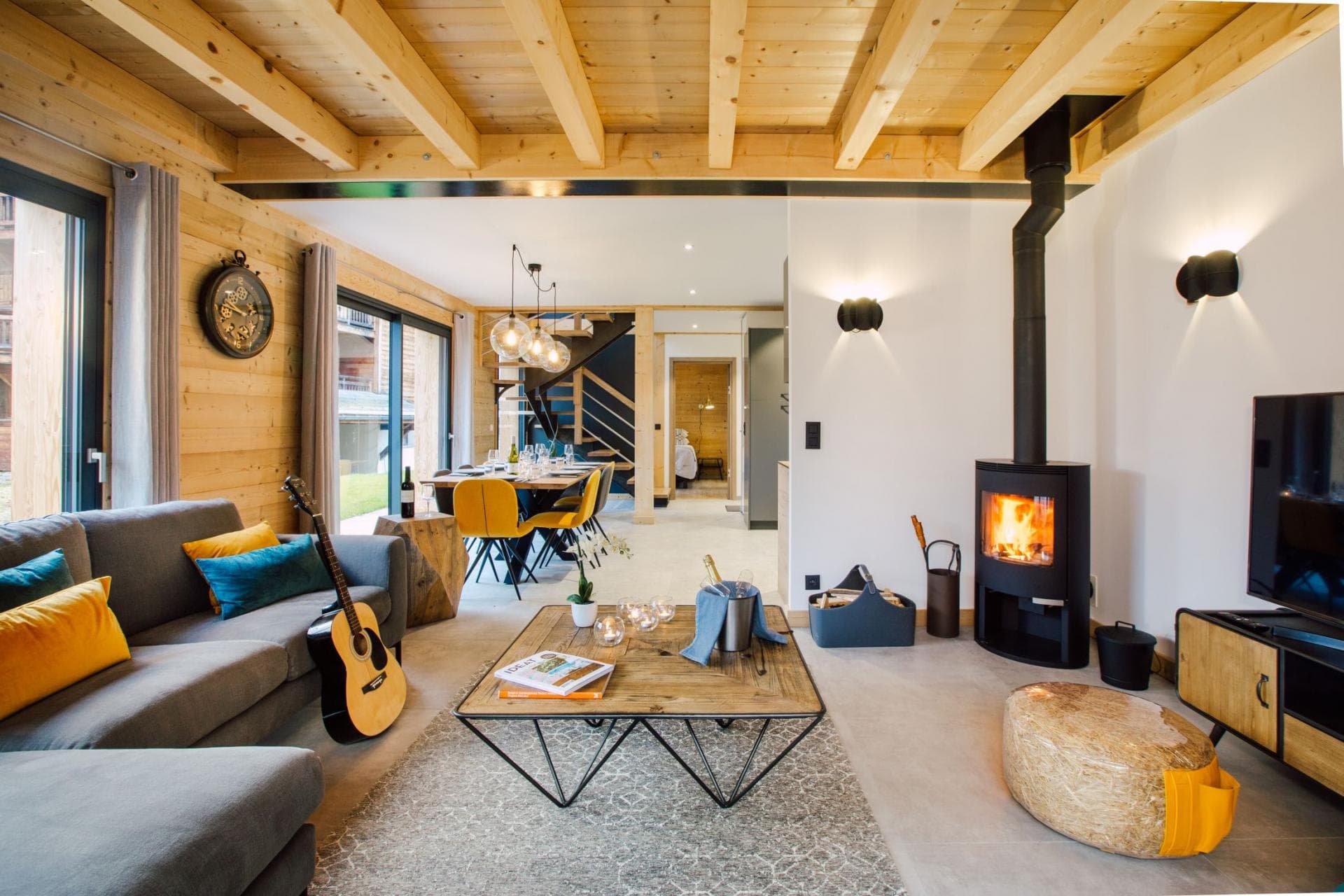 Open-plan living area with wood-burning stove and dining seating for 6