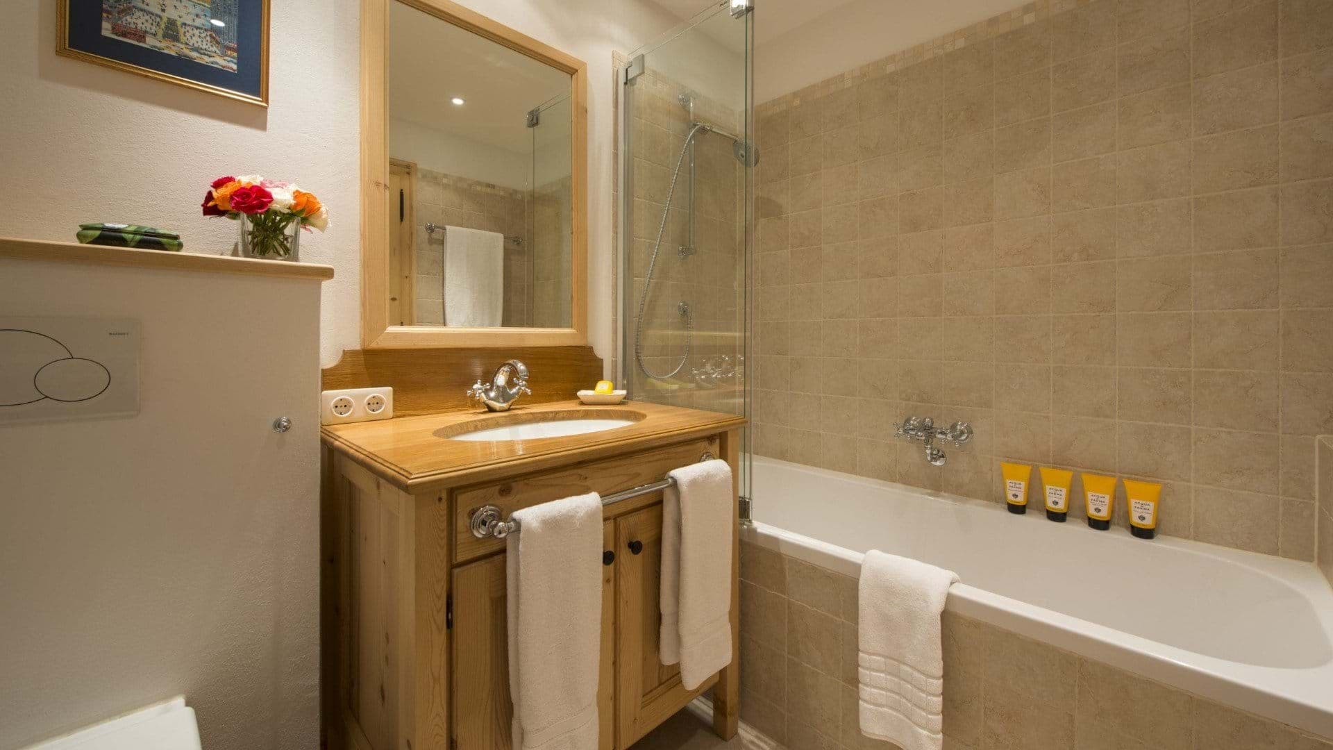 Bathroom featuring soaking tub with shower wand and glass partition