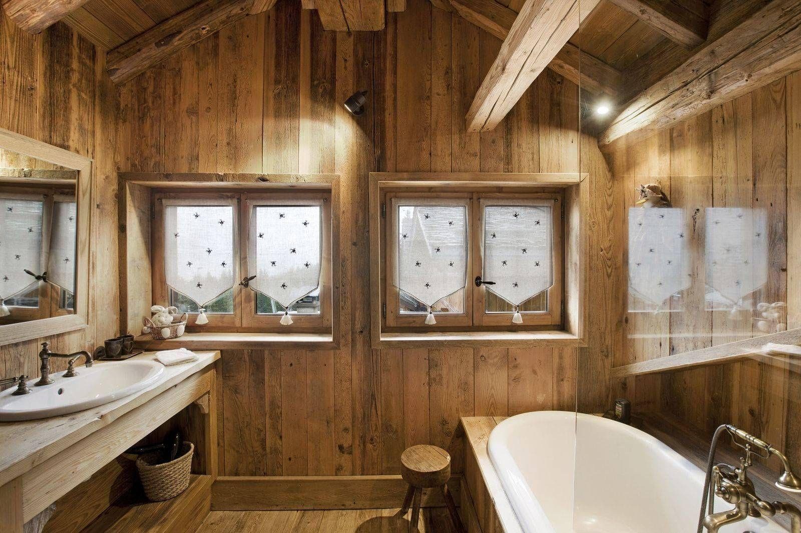 Bathroom with soaking tub, vessel sink, and reclaimed wood walls