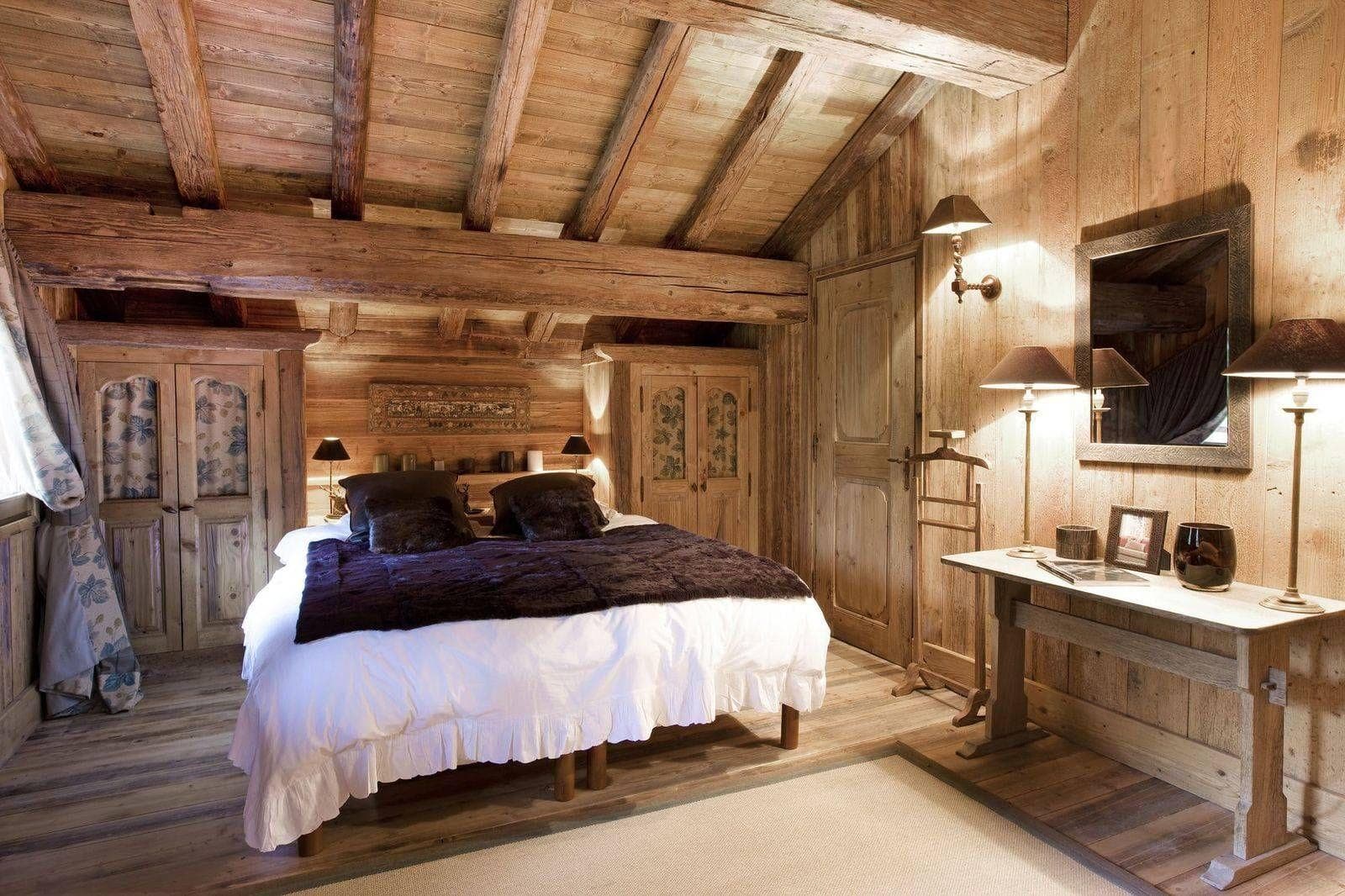 Wood-paneled bedroom with king bed and original exposed timber beams