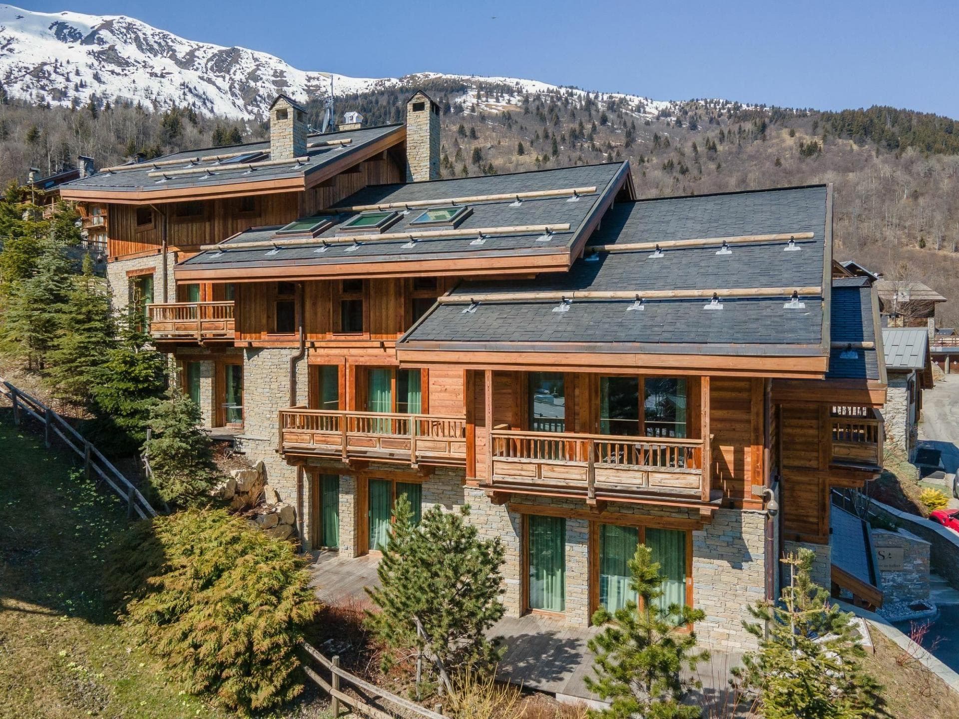 Chalet exterior with multiple private balconies and mountain views