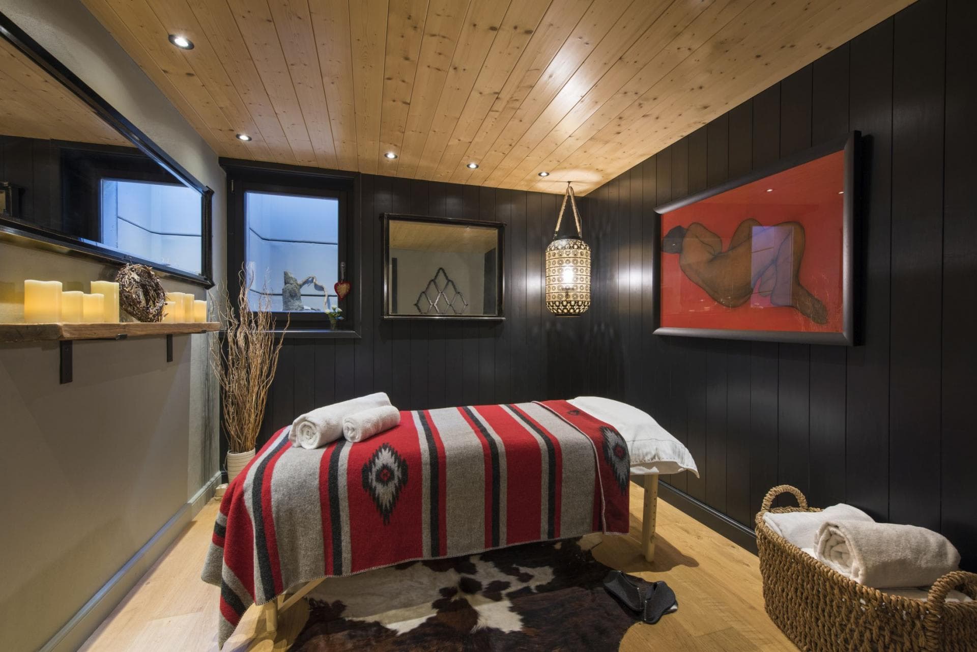 Private massage room with wood-paneled ceiling and provided linens