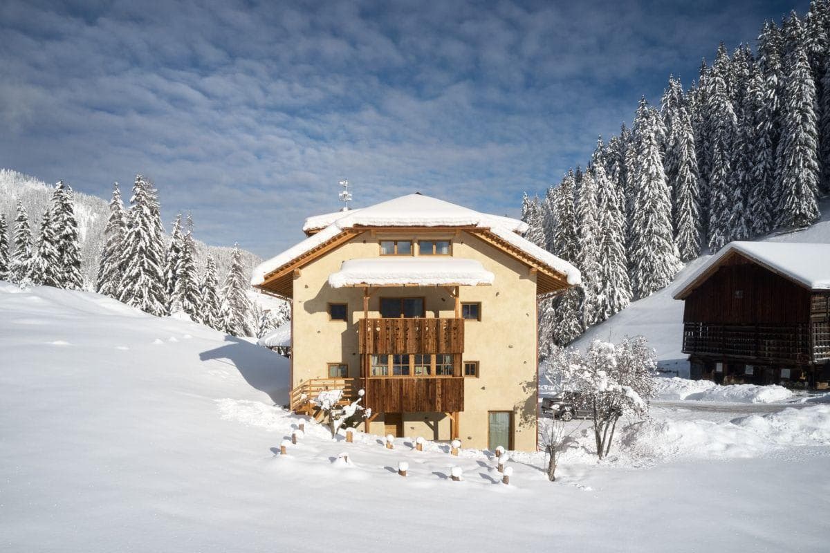 Chalet exterior with timber balconies and direct snowy mountain access