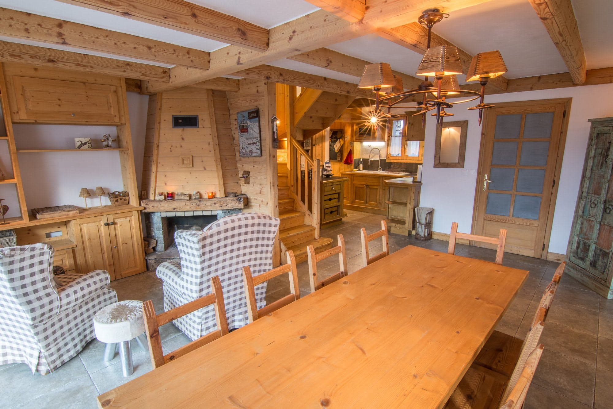 Open-plan dining area and lounge with fireplace and exposed wood beams