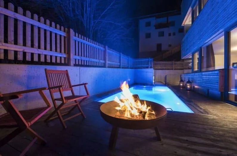 Outdoor terrace with a fire pit beside the heated pool