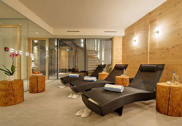 Wellness area with woven loungers and glass-enclosed sauna entrance