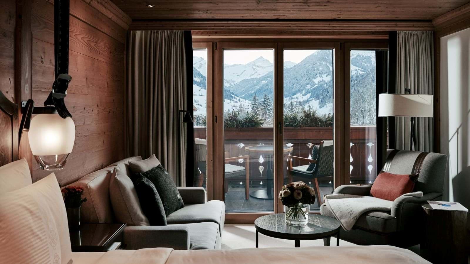 Guest suite with seating area and private balcony overlooking snow-covered mountains