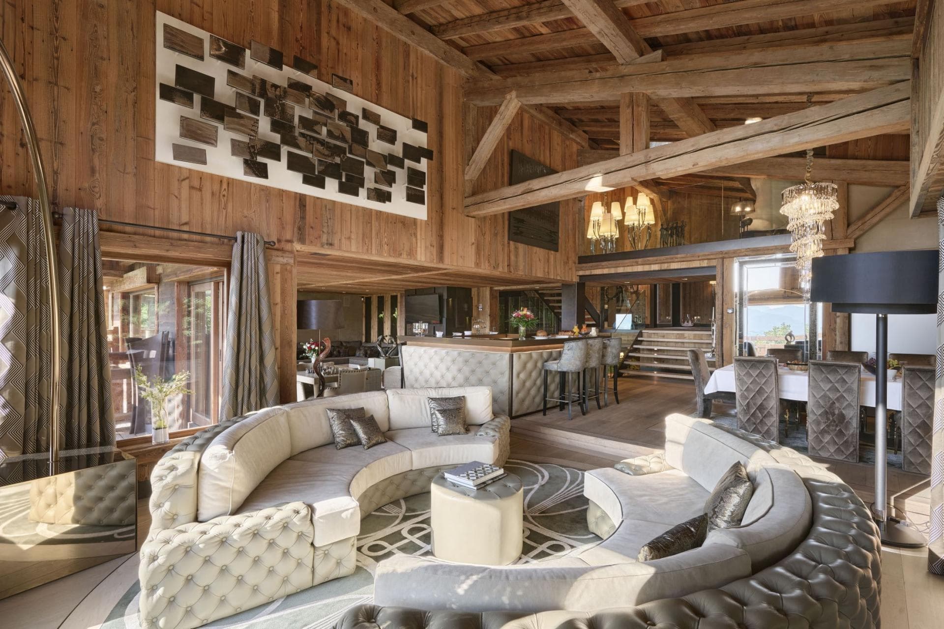 Open living area with circular sectional, wet bar, and loft access