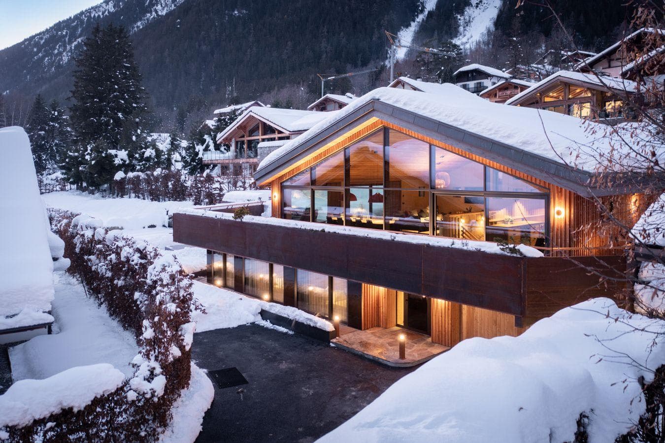Ski chalet exterior with floor-to-ceiling windows and private parking area