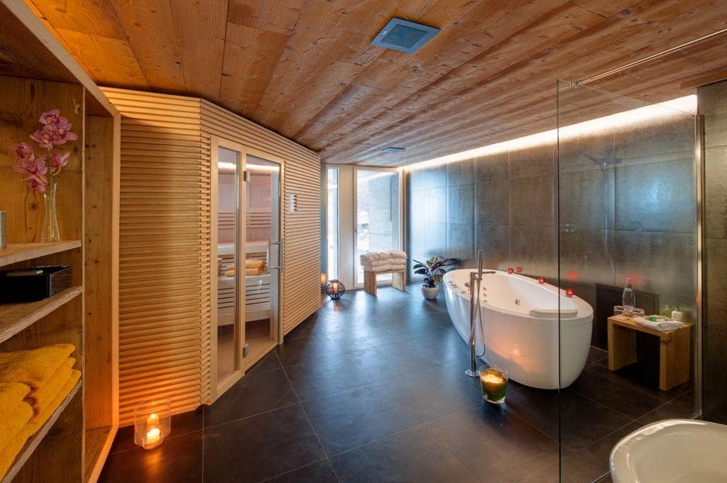Spa bathroom with wood-paneled sauna and freestanding soaking tub