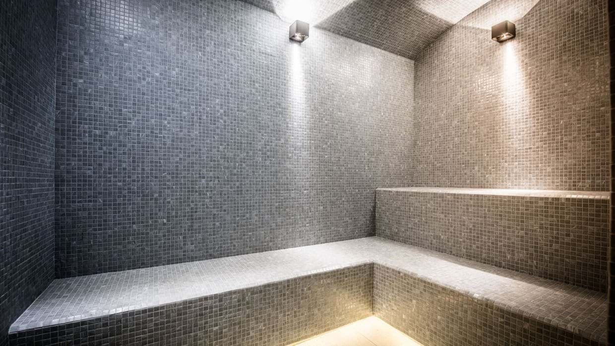 Private steam room with mosaic tile and multi-level seating