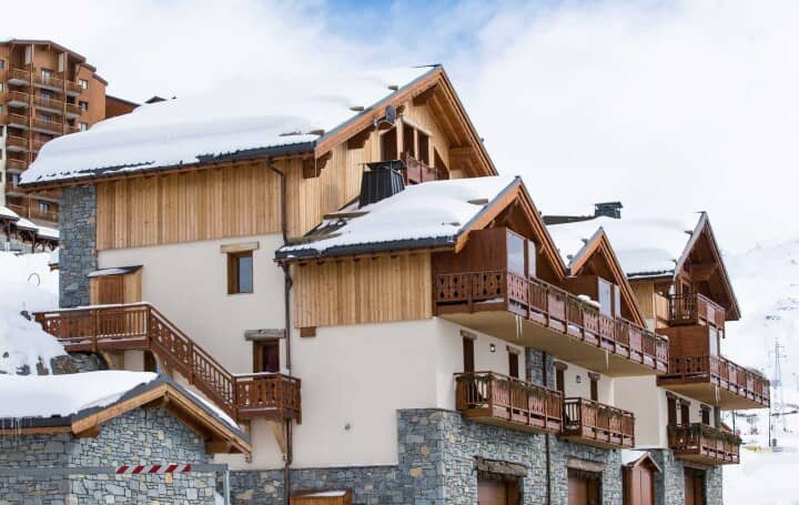 Chalet exterior with multiple private balconies and natural stone masonry