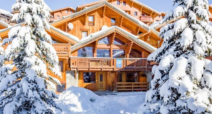 Timber chalet with multiple balconies and floor-to-ceiling windows