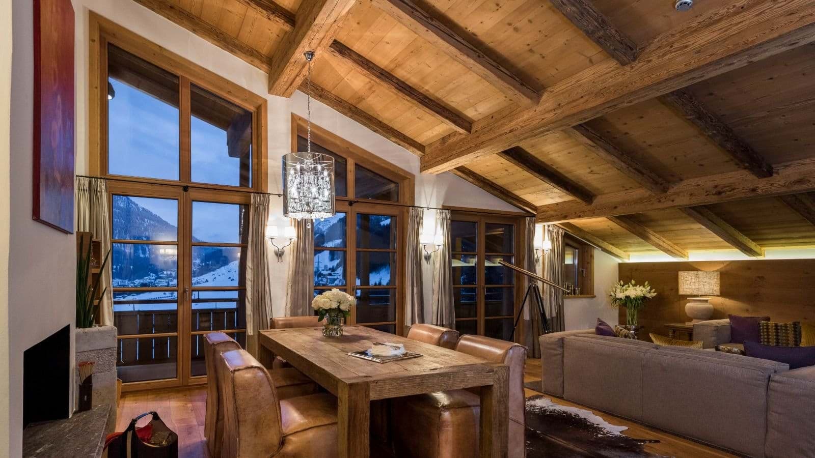 Open-plan dining area with vaulted timber ceilings and village views