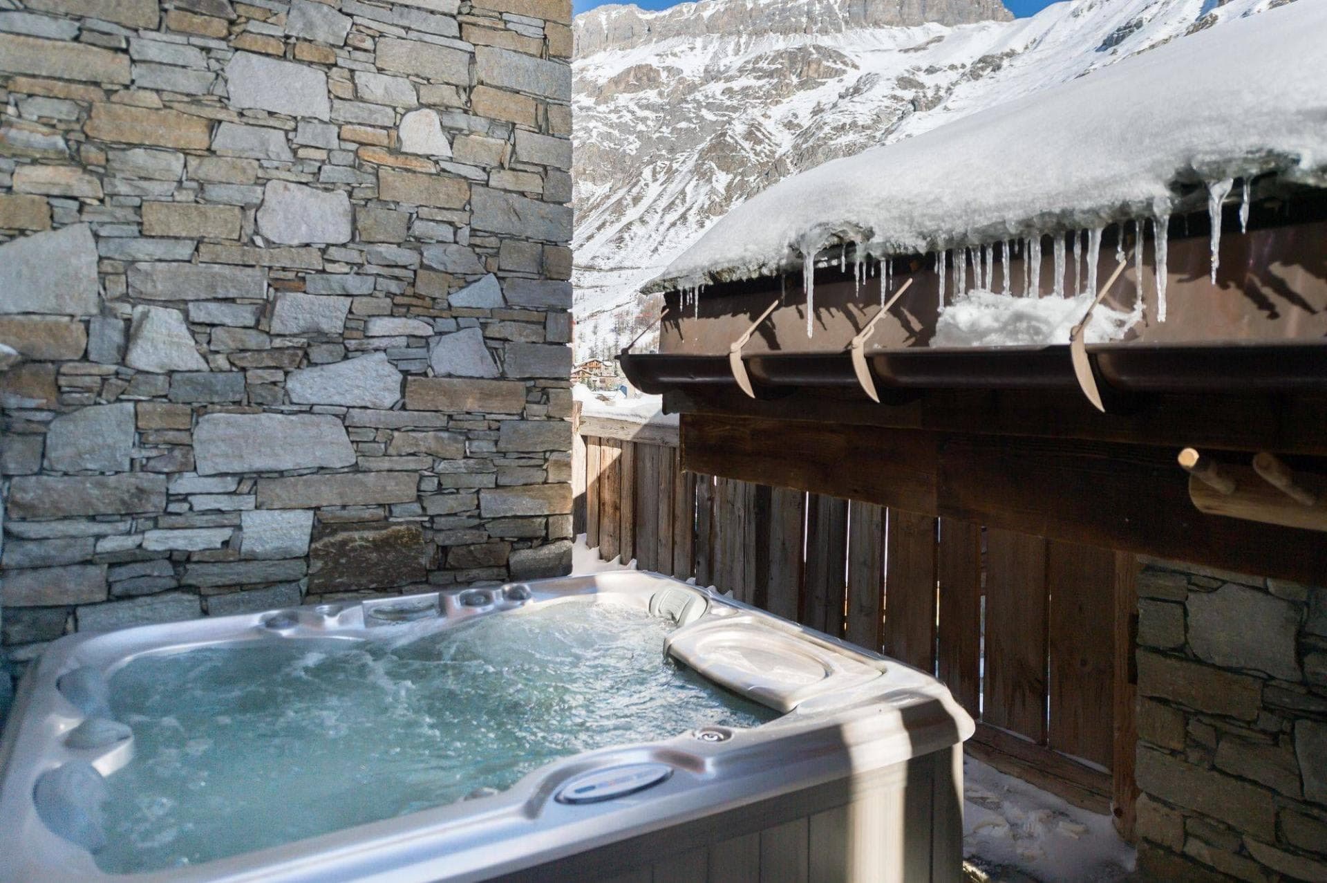 Private outdoor hot tub with mountain views and stone wall privacy