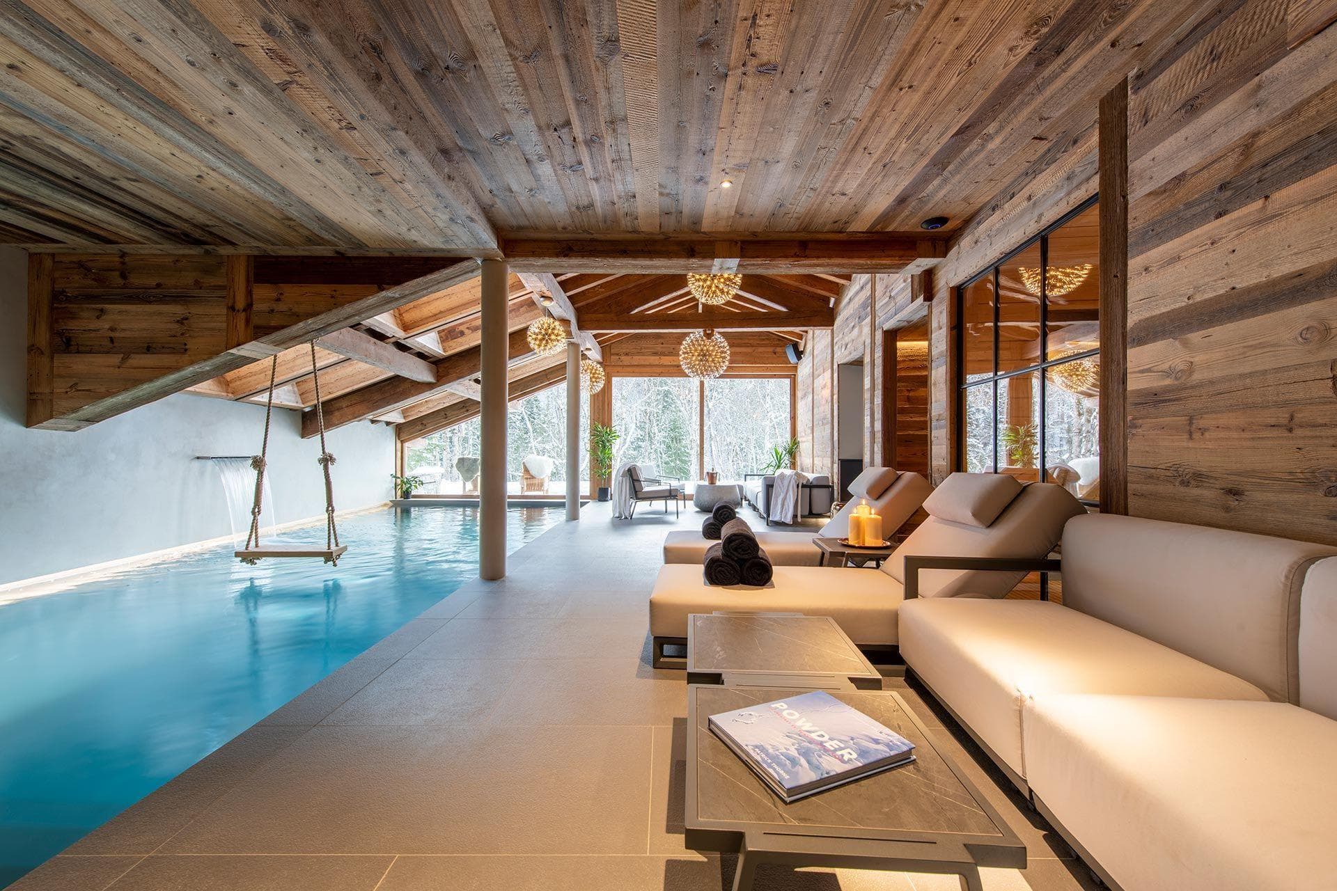 Indoor pool with over-water swing and poolside lounge seating