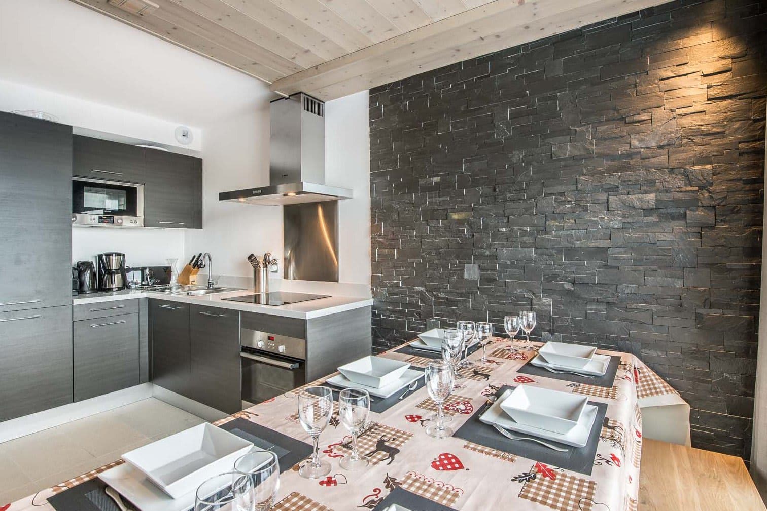 Kitchen and dining area with induction cooktop and stone feature wall