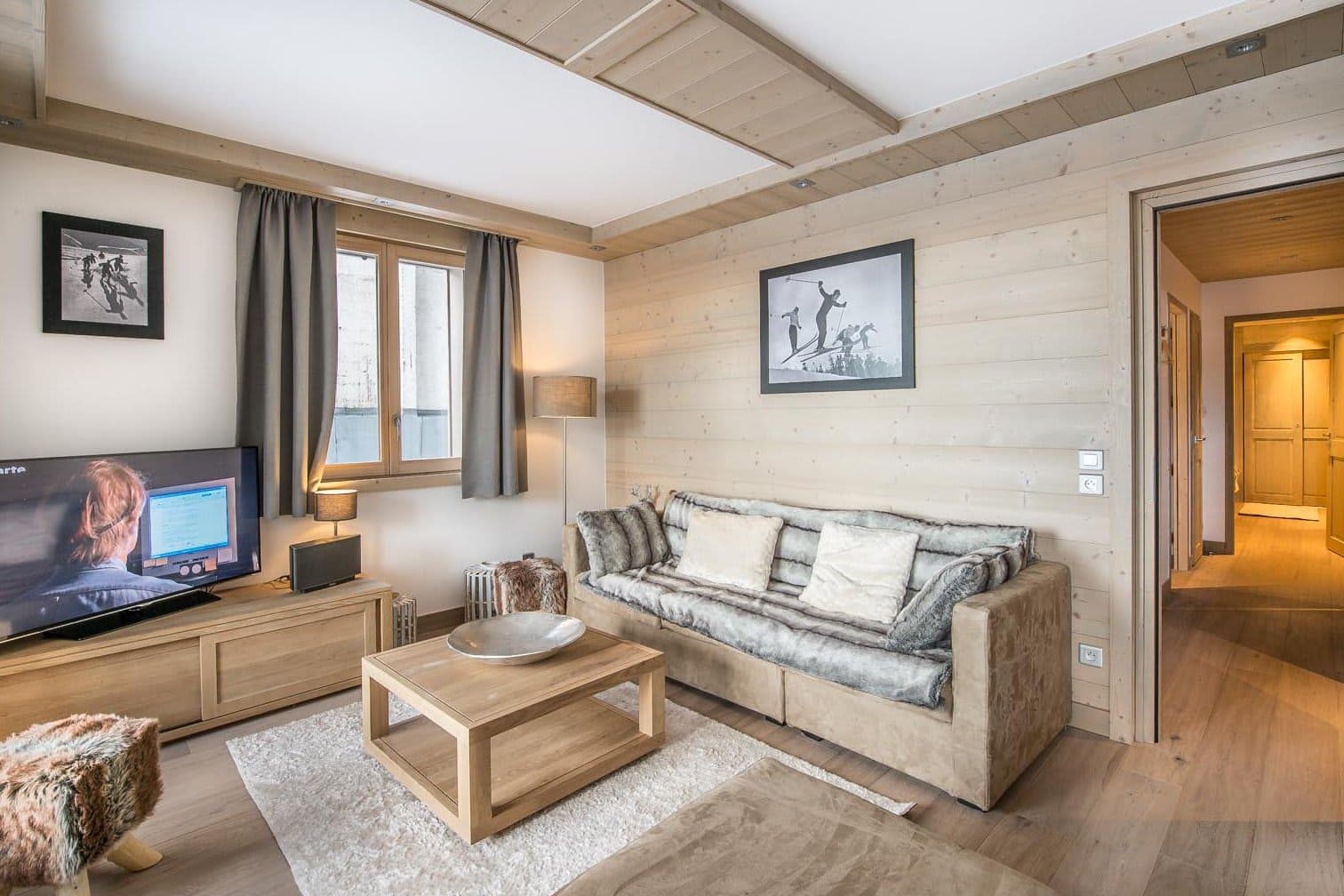 Living area with smart TV and light wood paneled walls