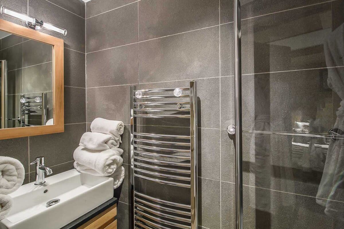 Bathroom with walk-in glass shower and heated towel rail