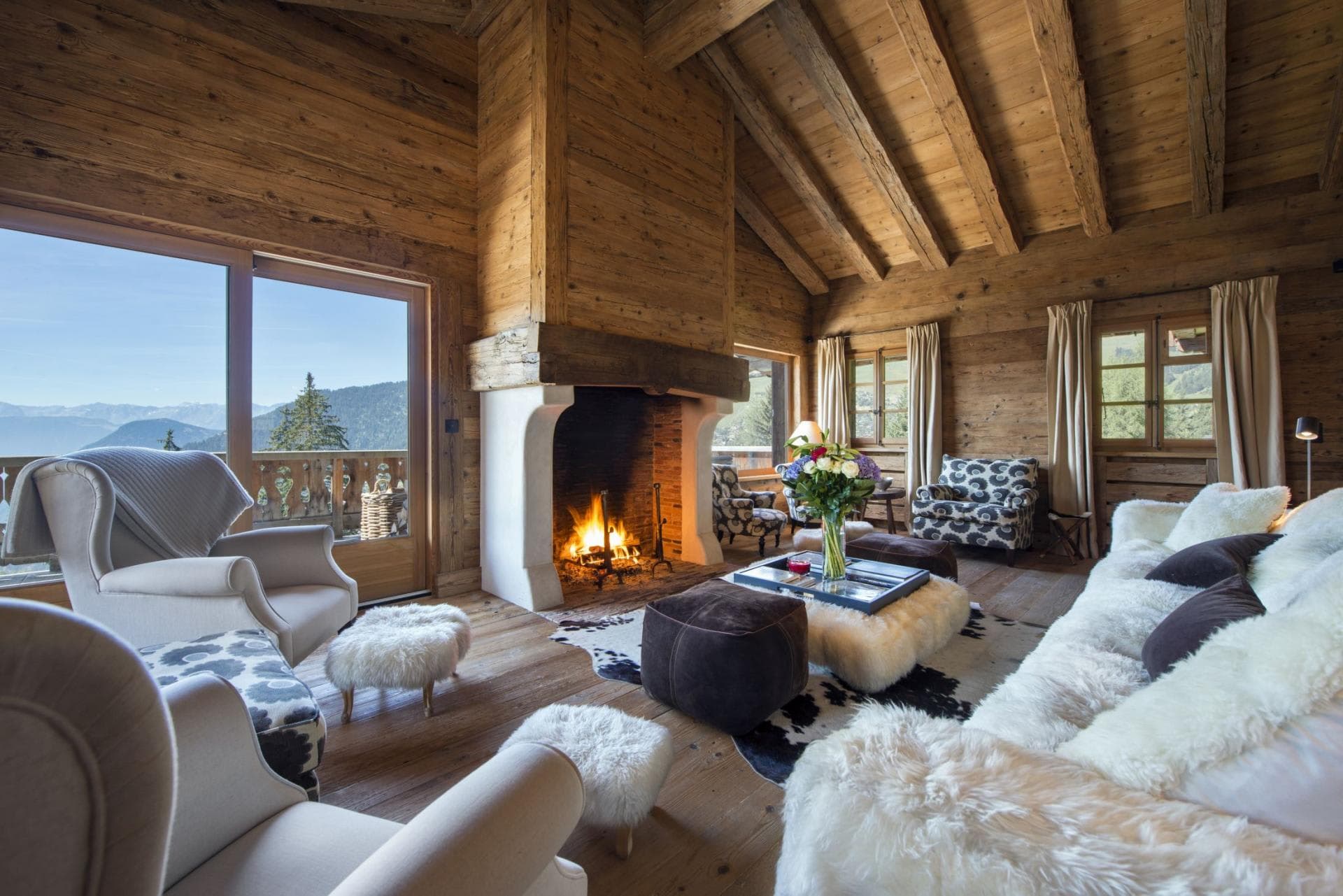 Living area with wood-burning fireplace and mountain-view balcony access