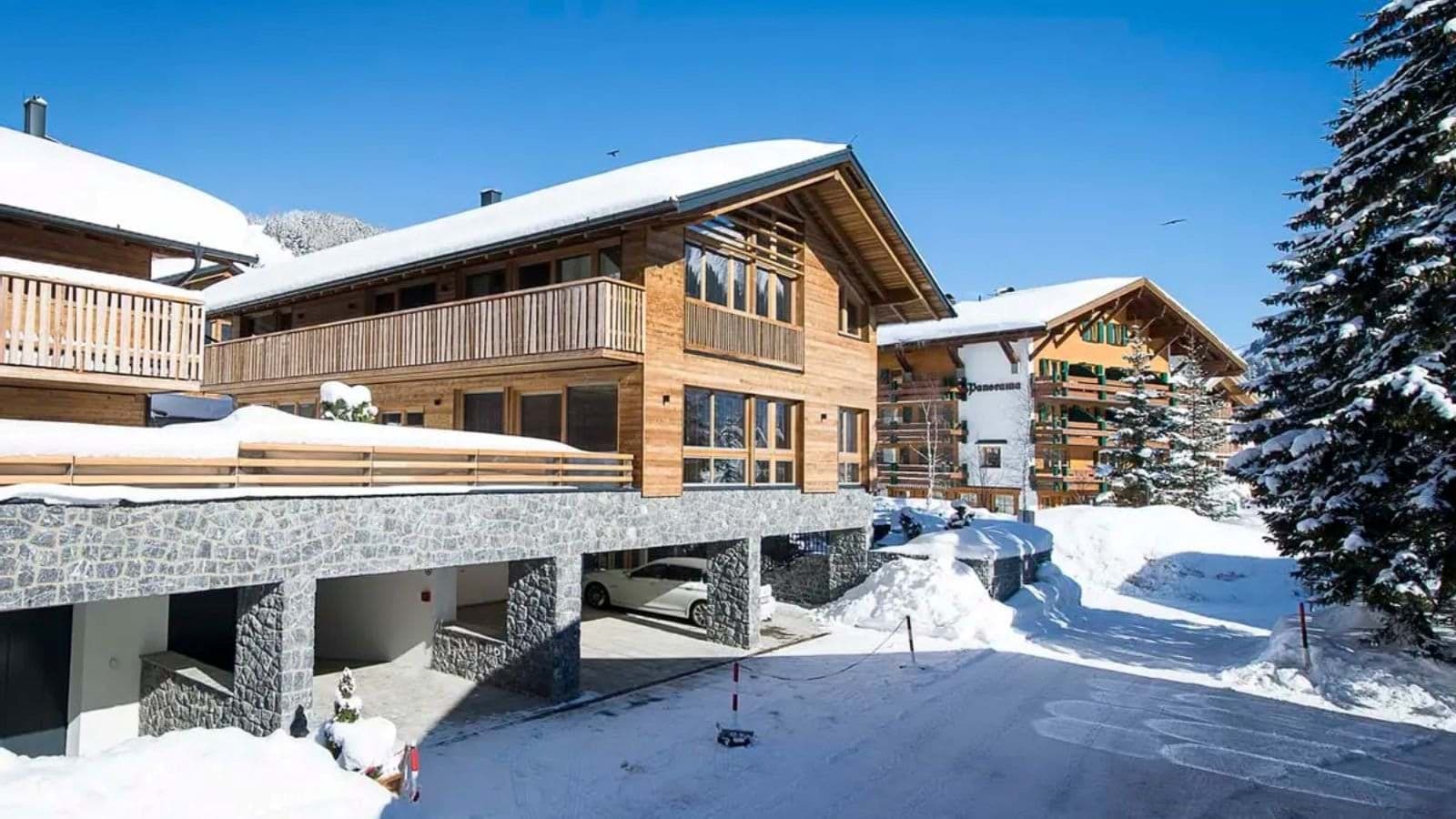 Chalet exterior with covered stone parking bays and private balcony