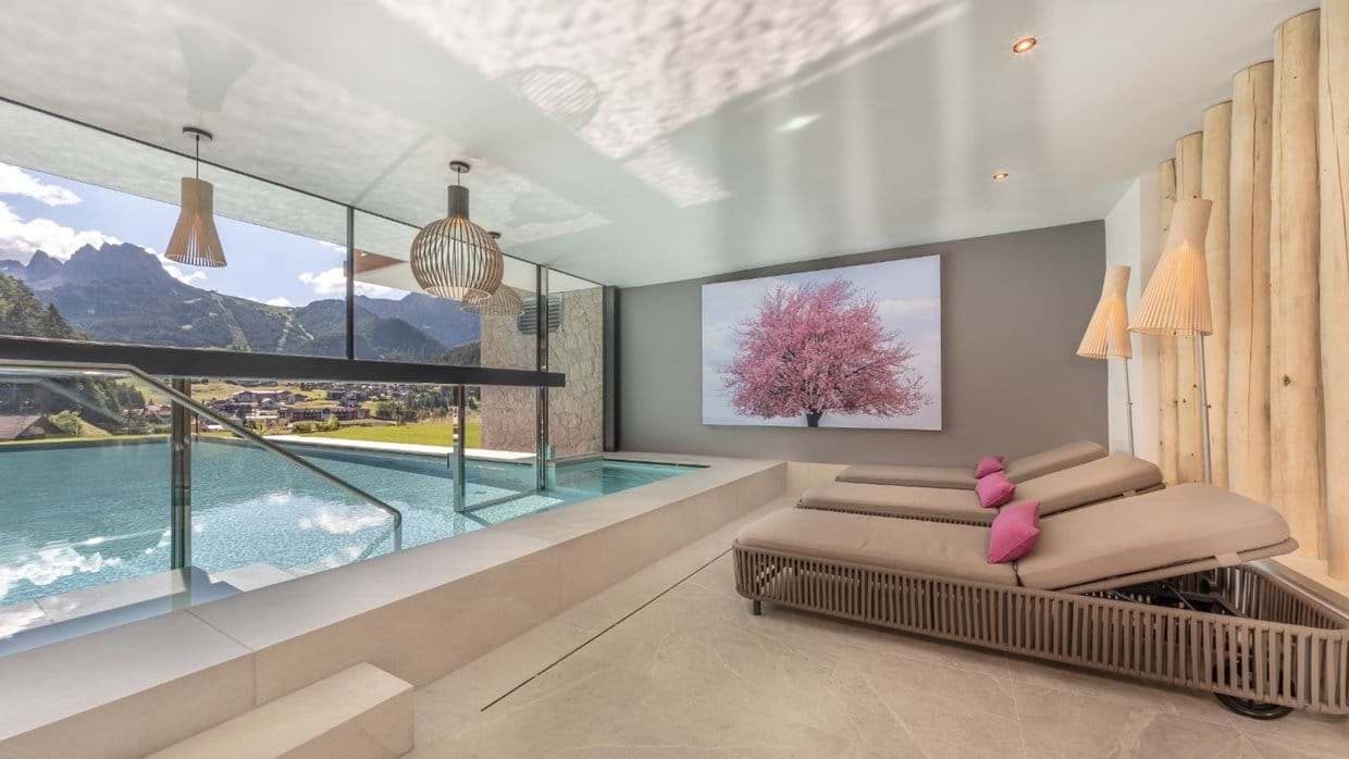 Indoor-outdoor heated pool with mountain views and poolside loungers
