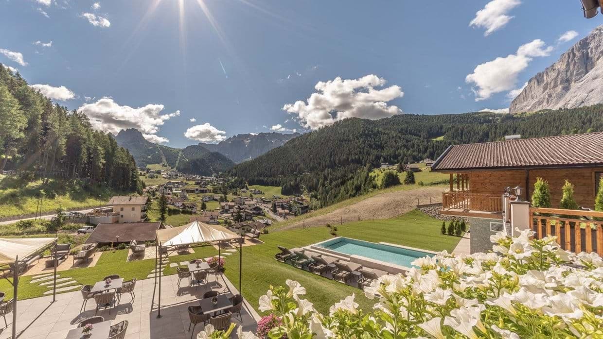 Terrace with heated outdoor pool and panoramic Dolomite mountain views