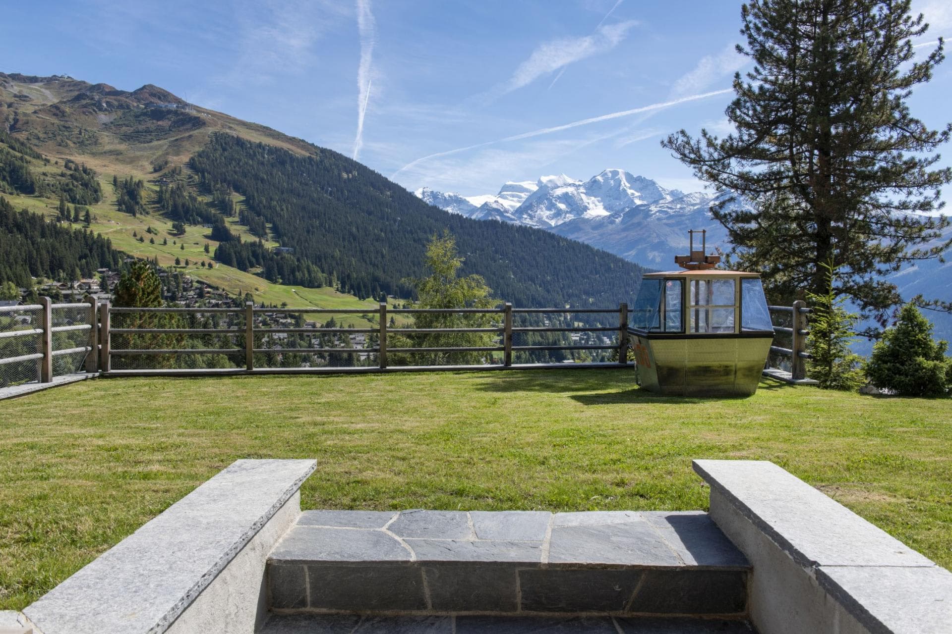 Lawn with alpine views featuring a vintage cable car cabin
