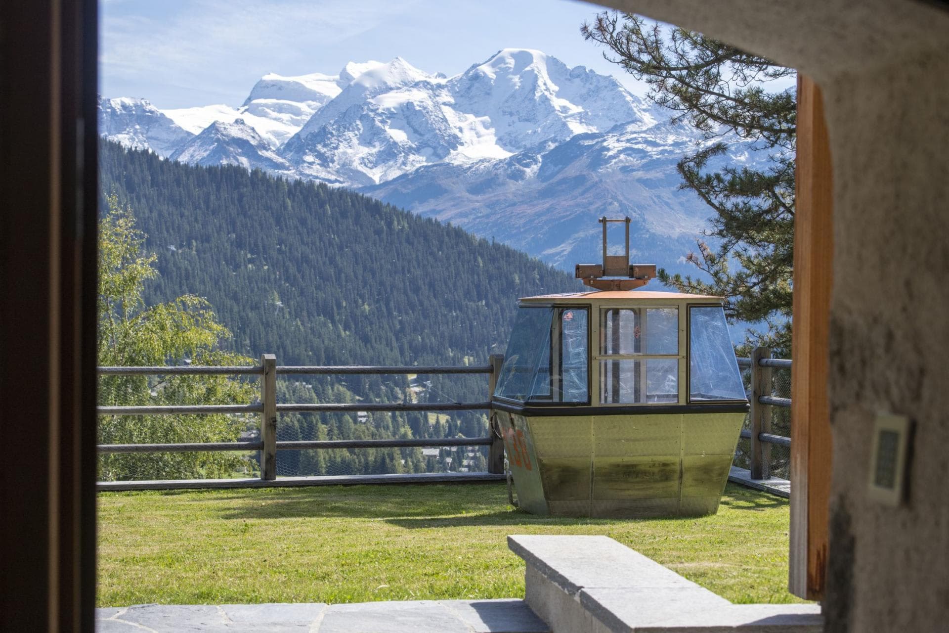Private lawn with vintage cable car cabin and mountain views