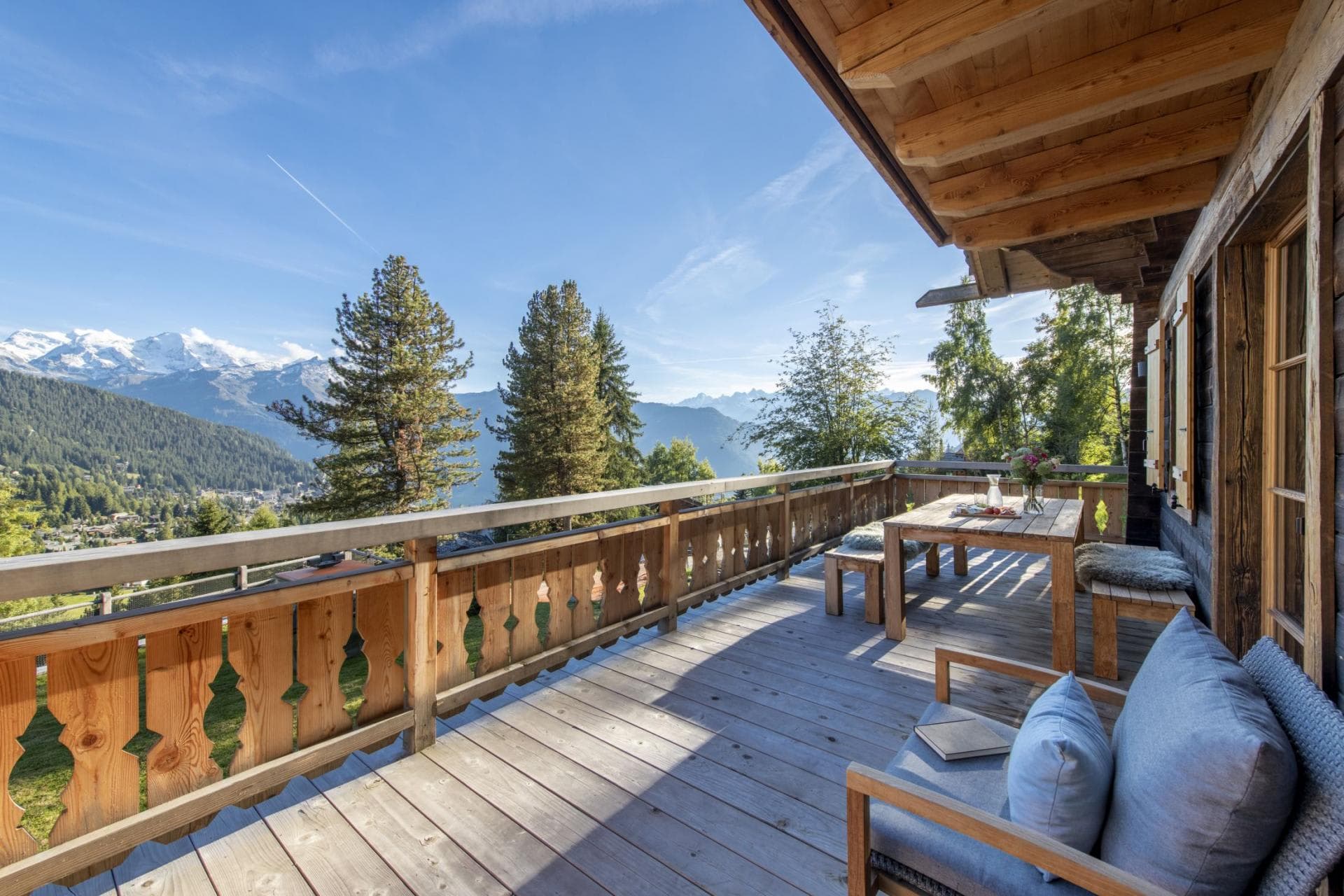 Wooden balcony with outdoor dining table and mountain valley views