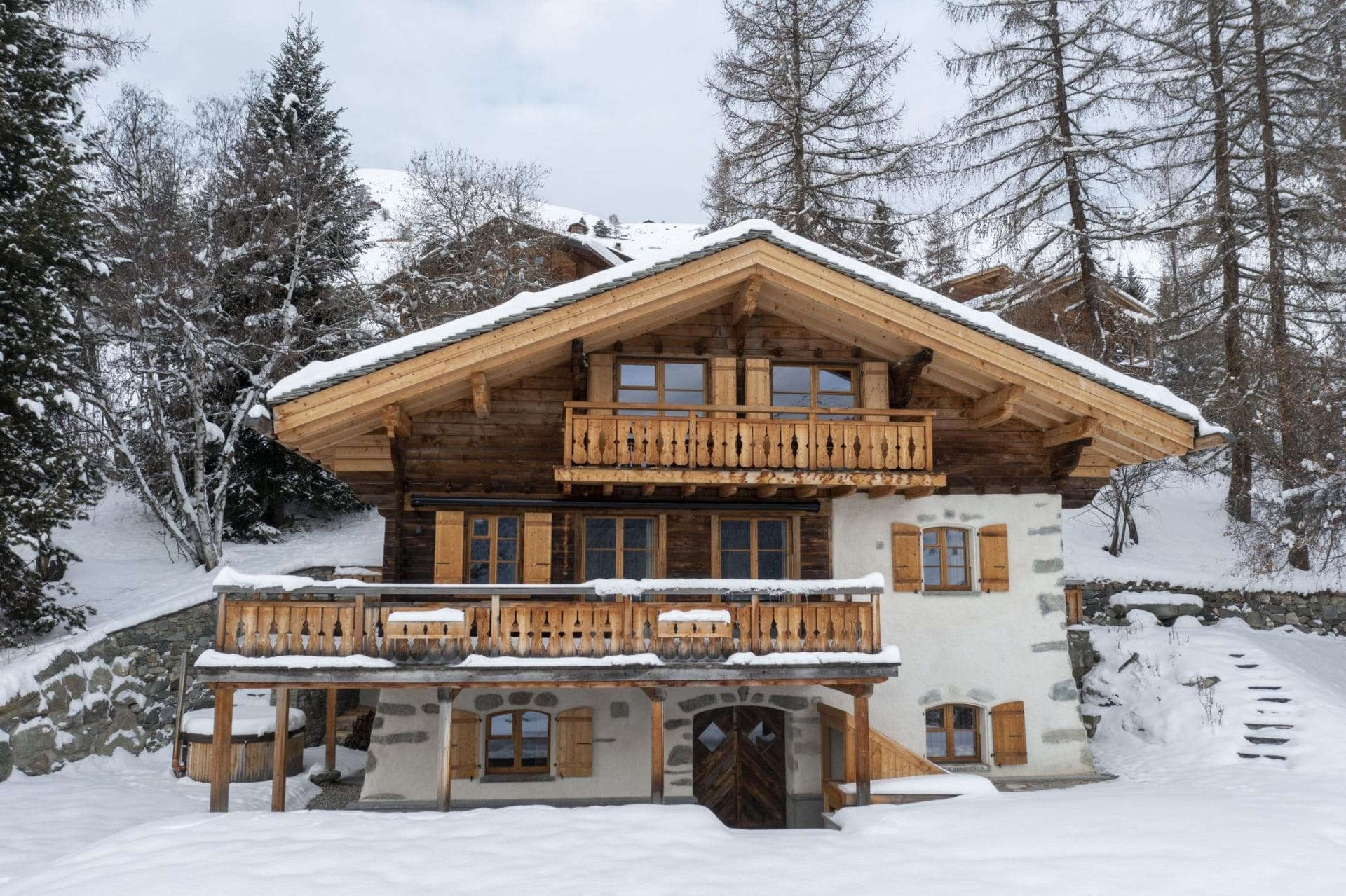 Three-story chalet with wooden balconies and covered outdoor hot tub